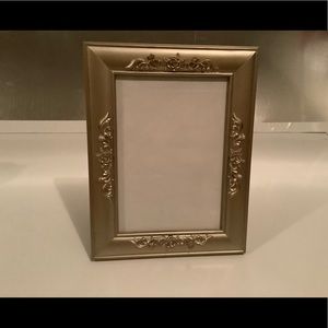😊Gold colored picture frame, by Decoral, holds 5”X7” can stand or hang on wall.